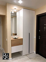 Встраиваемый шкаф из ЛДСП Egger. За зеркалом, декорированным фацетом, находится зона хранения.