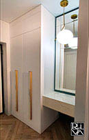 Встраиваемый шкаф в прихожей. Материал фасадов - матовый крашенный МДФ. Корпус шкафа - ЛДСП Egger. Интегрированная в изделие консоль отделана глянцевым керамогранитом Laminam. Ручки выполнены из массива дуба, окрашены в цвет «золото».