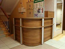 Стойка регистрации (ресепшн) в административном здании. Используются гнутые ДСП.